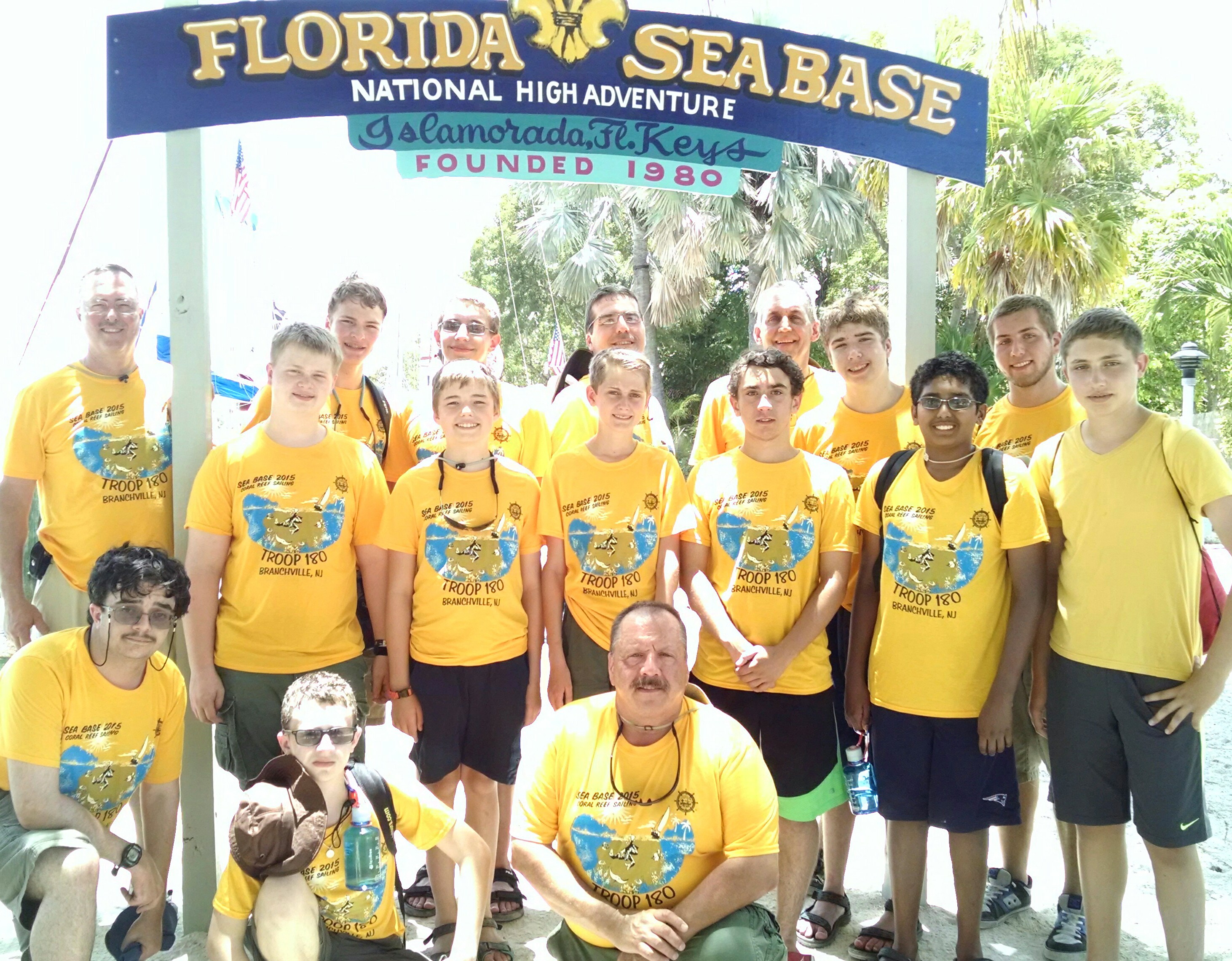 Troop 180 is shown wearing their gold Classic Fit Performance T-Shirts from Class B in front of the Florida Sea Base Camp